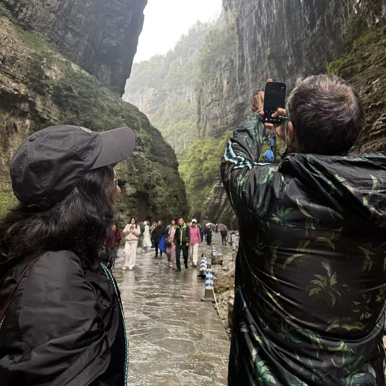 Travelers beneath Wulong's natural bridges with clear scale and lush scenery